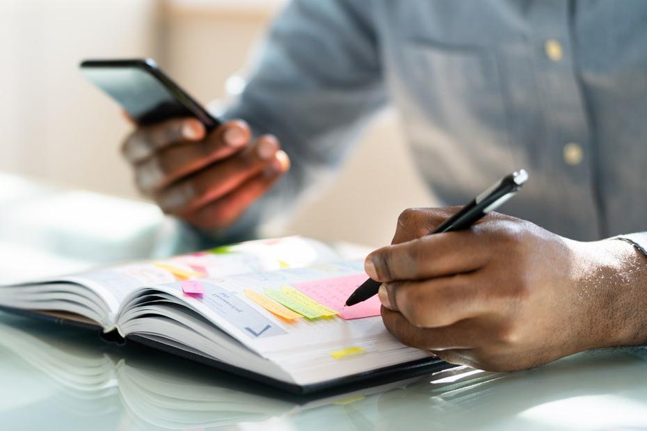 A man writing in his weekly planner